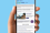 Image of hand holding a phone on a blue background - phone displays the Global Trade Today newsletter