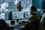 Military figures in a command centre working on a laptop