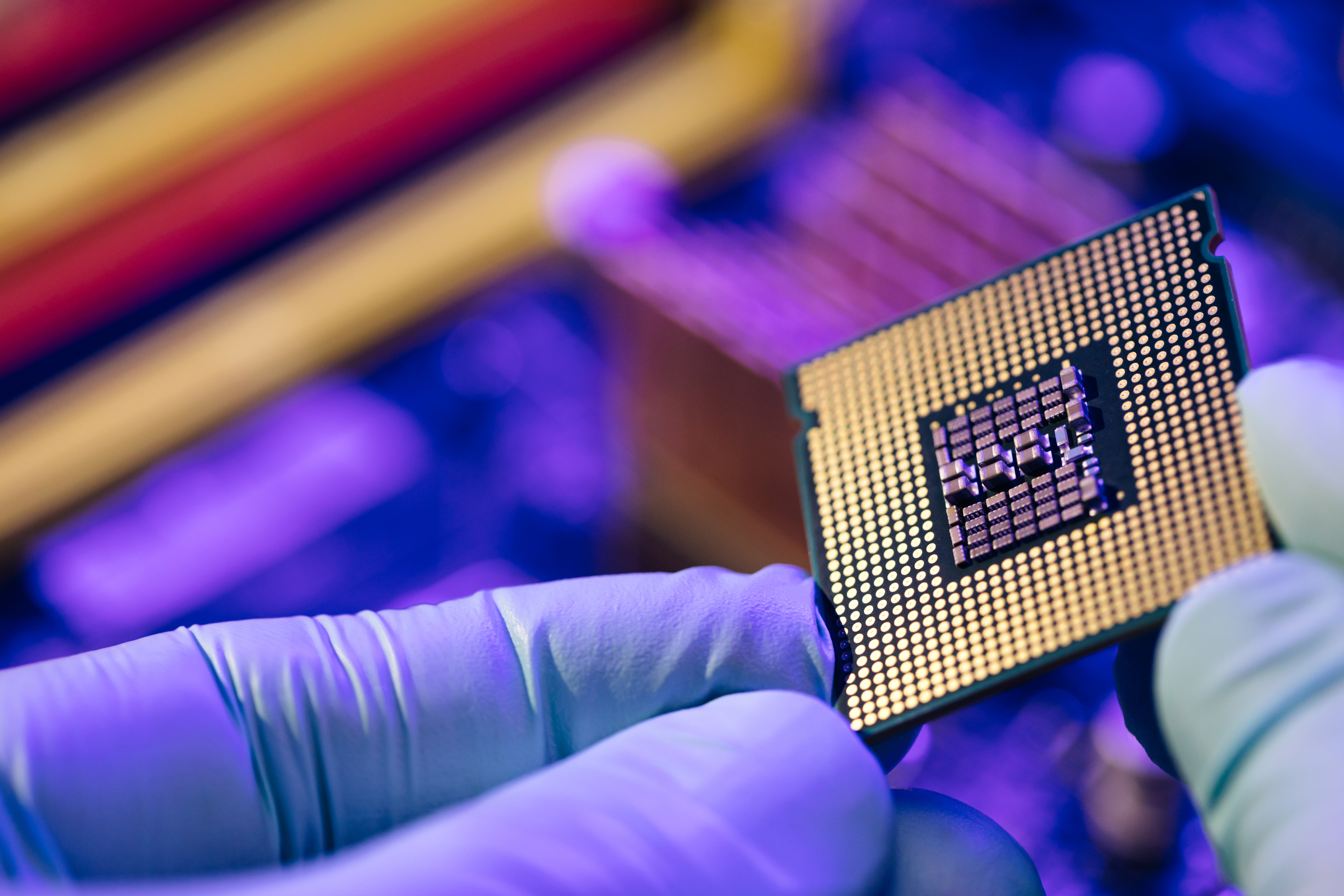 Semi conductor chip being handled during production by worker in factory